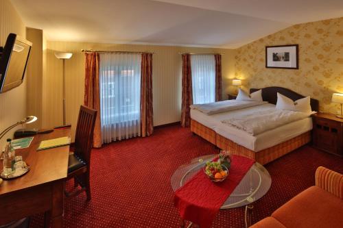 a hotel room with a bed and a table at Hotel Elefant in Schwerin
