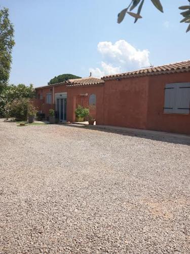 a house with a gravel driveway next to a building at Petit Lézard in Draguignan