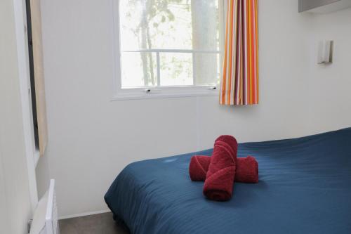 un lit avec deux animaux farcis rouges dans l'établissement Taluna, à Agde