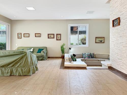 a living room with a couch and a table at 200m do mar - AC - Piscina - Churrasqueira - 1 Suite in Guarujá