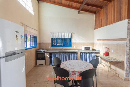 a kitchen with a table and chairs and a refrigerator at Sitio em Sumare com piscina e lazer completo in Sumaré