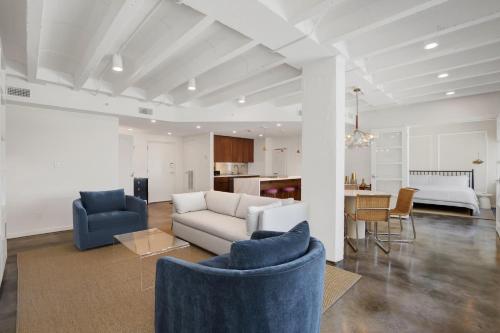 a living room with two blue chairs and a couch at Liberty Mid-Century in Savannah