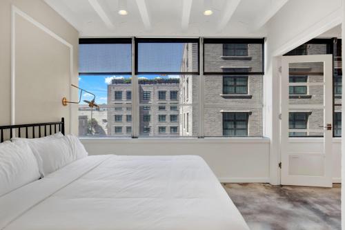 a bedroom with a white bed and a large window at Liberty Mid-Century in Savannah