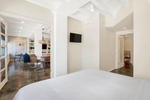 a white bedroom with a bed and a dining room at Liberty Mid-Century in Savannah