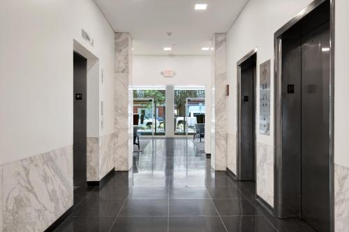 a hallway with black doors and marble walls at Liberty Mid-Century in Savannah