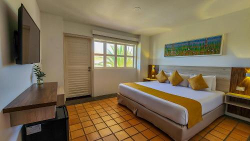 a hotel room with a bed and a television at Sunsol Ecoland in Pedro Gonzalez