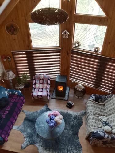 a living room with a couch and a fire place at Cabañas Alturas Chillan Katalina in Chillán