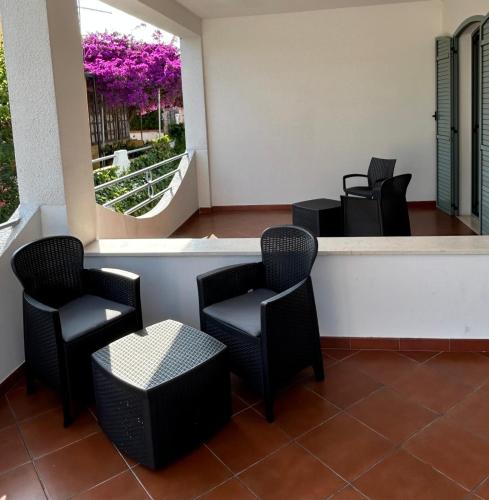 a waiting area with chairs and a window with purple flowers at Hotel La Meridiana in San Domino