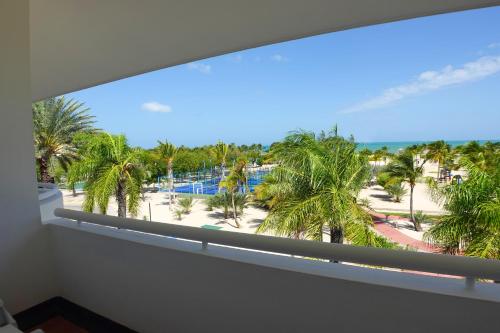 a balcony with a view of a beach and palm trees at Sunsol Ecoland in Pedro Gonzalez