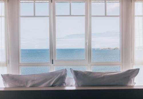 a view of the ocean through an open window at Les Bassans in Perros-Guirec