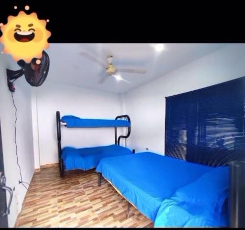 a bedroom with two beds and a ceiling fan at Casa Paradise in Carmen de Apicalá