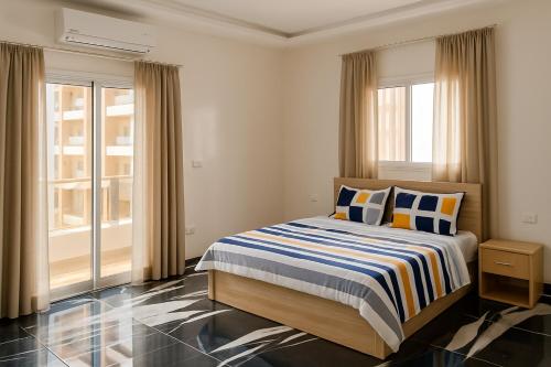 a bedroom with a bed with blue and yellow pillows at Appartement Meublé aux Almadies Élégance Confort et Sérénité in Ngor