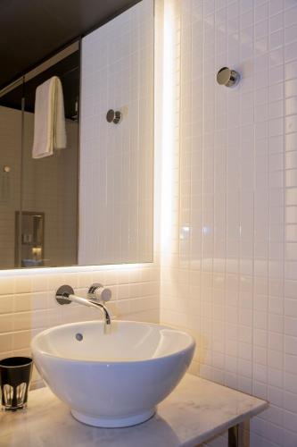 a bathroom with a white sink and a mirror at Mama Shelter Lisboa in Lisbon