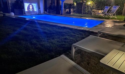 a swimming pool in a yard at night at Shati Luxury - New, Heated Pool, Sea view Near beach in Fontane Bianche