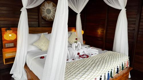 a bedroom with a bed with white drapes at Eco Oasis Wooden Villa Ubud in Tegalalang