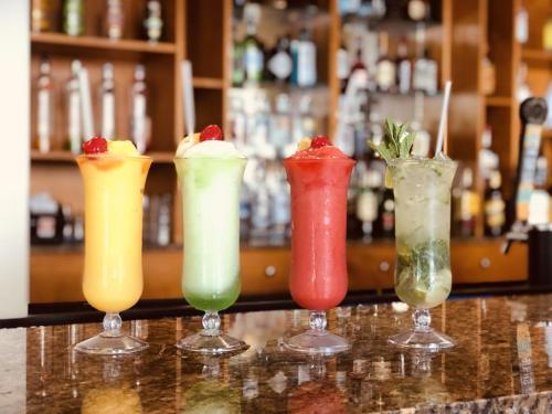 four different colored cocktails sitting on a bar at Villa Renaissance Unit 501 Grace Bay Beach in The Bight Settlements