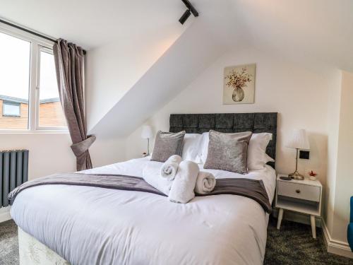 a bedroom with a large bed with towels on it at Lilly's Cottage in Dawlish