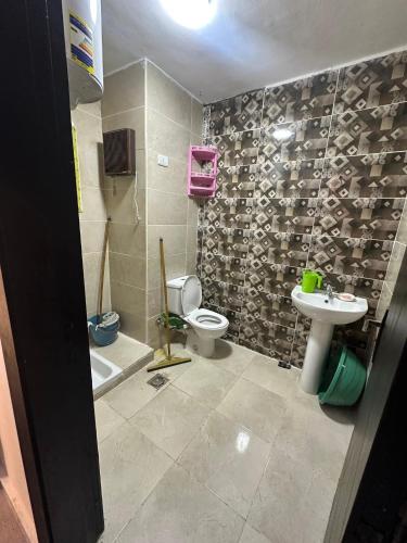 a bathroom with a toilet and a sink at شاليه بقرية اكوافيو in El Alamein