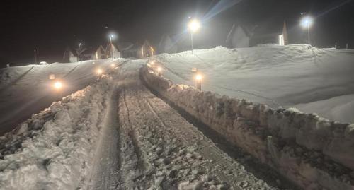 a street covered in snow at night with street lights at Family Resort Plitvice Lakes in Rastovača