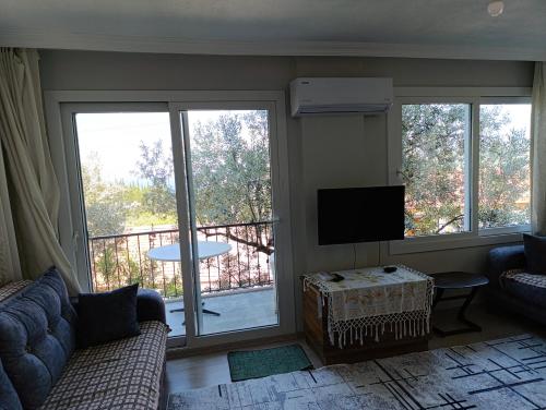 a living room with a couch and a flat screen tv at Olive grove mansion - kösedere village in Karaburun
