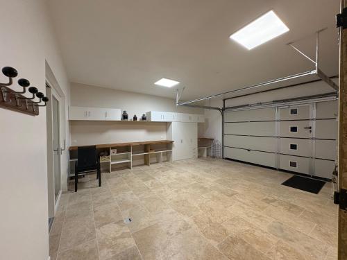 an empty garage with white cabinets and a tile floor at L'Ecrin des Marronniers in Abondant