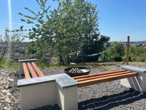 a wooden bench with a fire pit in a park at La Tiny de Margny in Margny-lès-Compiègne