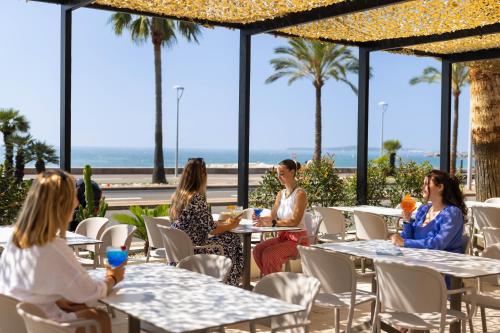 a group of women sitting at tables in a restaurant at Hotel Royalmar - Nouveau propriétaire in Cagnes-sur-Mer