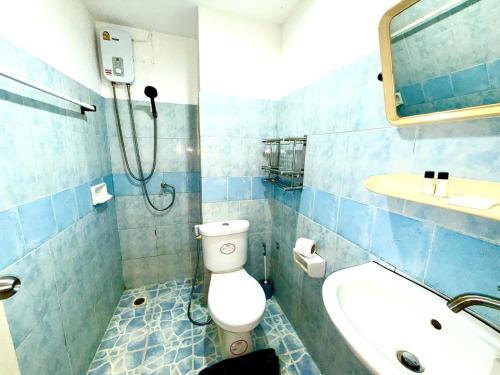 een blauw betegelde badkamer met een toilet en een wastafel bij Patong Canal Villa R202 in Patong Beach