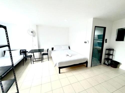 een slaapkamer met een bed, een tafel en een spiegel bij Patong Canal Villa R202 in Patong Beach