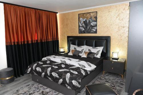 a bedroom with a bed with a black and white comforter at Luxury Home in Cîmpulung
