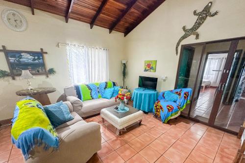 Una sala de estar con dos sofás y una mesa. en Casa Oasis in the center of Puerto Jimenez, en Puerto Jiménez