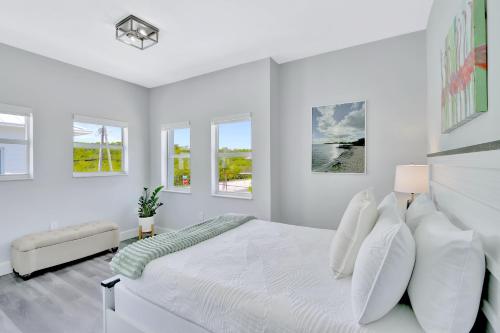キーラーゴにあるKeys Harbor - Waterfront, Private Boat Dock, Outdoor Oasisの白いベッドルーム(大型ベッド1台、白い枕付)