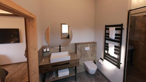 a bathroom with a sink and a mirror at Almhütte Auszeit - Neueröffnung Dezember 2025 in Saalbach Hinterglemm
