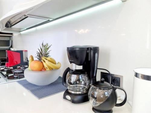 a kitchen counter with a blender and a bowl of fruit at Casa di Jiovanni Luxury in Asgourou