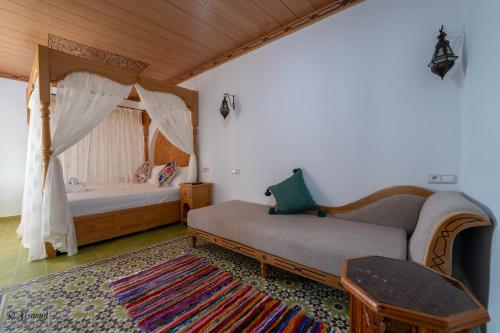 a bedroom with a bed and a couch in a room at Riad ALHAMBRA in Chefchaouene