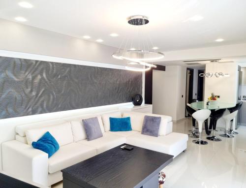 a living room with a white couch and blue pillows at Casa di Jiovanni Luxury in Asgourou