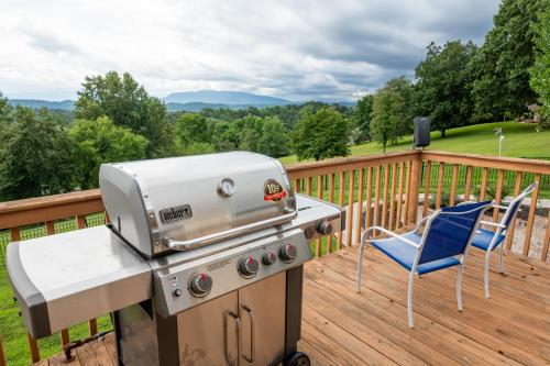 a grill and a chair on a deck with a view at Smoky Mountain Excellence By Avada Properties in Kodak