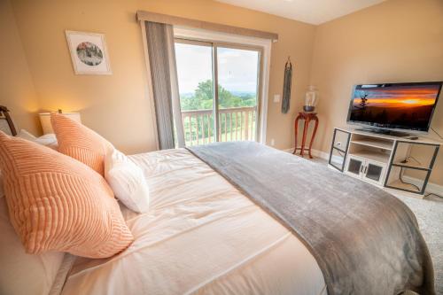 a bedroom with a large bed and a television at Smoky Mountain Excellence By Avada Properties in Kodak