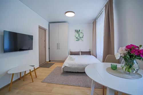a small living room with a table and a bed at Green Apartment with free parking in Kaunas