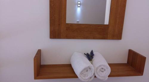 Baño con 2 toallas en un estante bajo un espejo en Apartment Lara, en Makarska