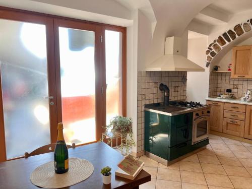 a kitchen with a table with a bottle of wine at Appartamento al volt in Tenno