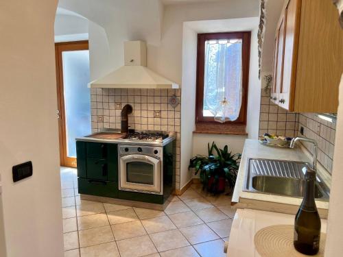 a kitchen with a stove and a sink at Appartamento al volt in Tenno