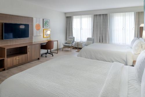 a hotel room with two beds and a flat screen tv at Holiday Inn Rock Hill by IHG in Rock Hill