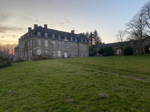 een groot gebouw bovenop een groen veld bij Château de Saint-Pois in Saint-Pois