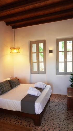 a bedroom with two beds and two windows at Lagadi House 2 in Arnados