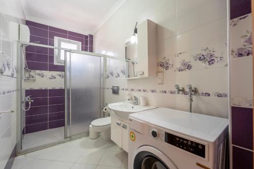 a bathroom with a toilet sink and a washing machine at A spacious, comfortable and cozy apartment close to the center of Fethiye in Fethiye