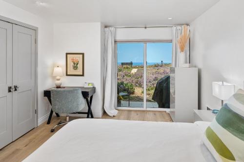 a bedroom with a bed and a desk and a window at Surf Song Symphony - SONG55 in Solana Beach