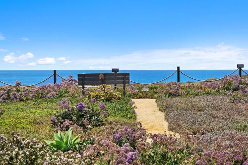 a bench sitting on top of a hill near the ocean at Surf Song Symphony - SONG55 in Solana Beach