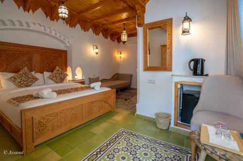 a bedroom with a large bed and a fireplace at Riad ALHAMBRA in Chefchaouene