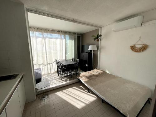 Camera con letto, tavolo e balcone. di Aux Jardins du Vidourle - 3 min à pied de la Plage, Parking, Clim & Wi-Fi a La Grande-Motte